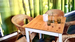 A wooden table with chairs and a lamp in a bamboo forest setting. - Hotel Klostermühle (Hann. Muenden)
