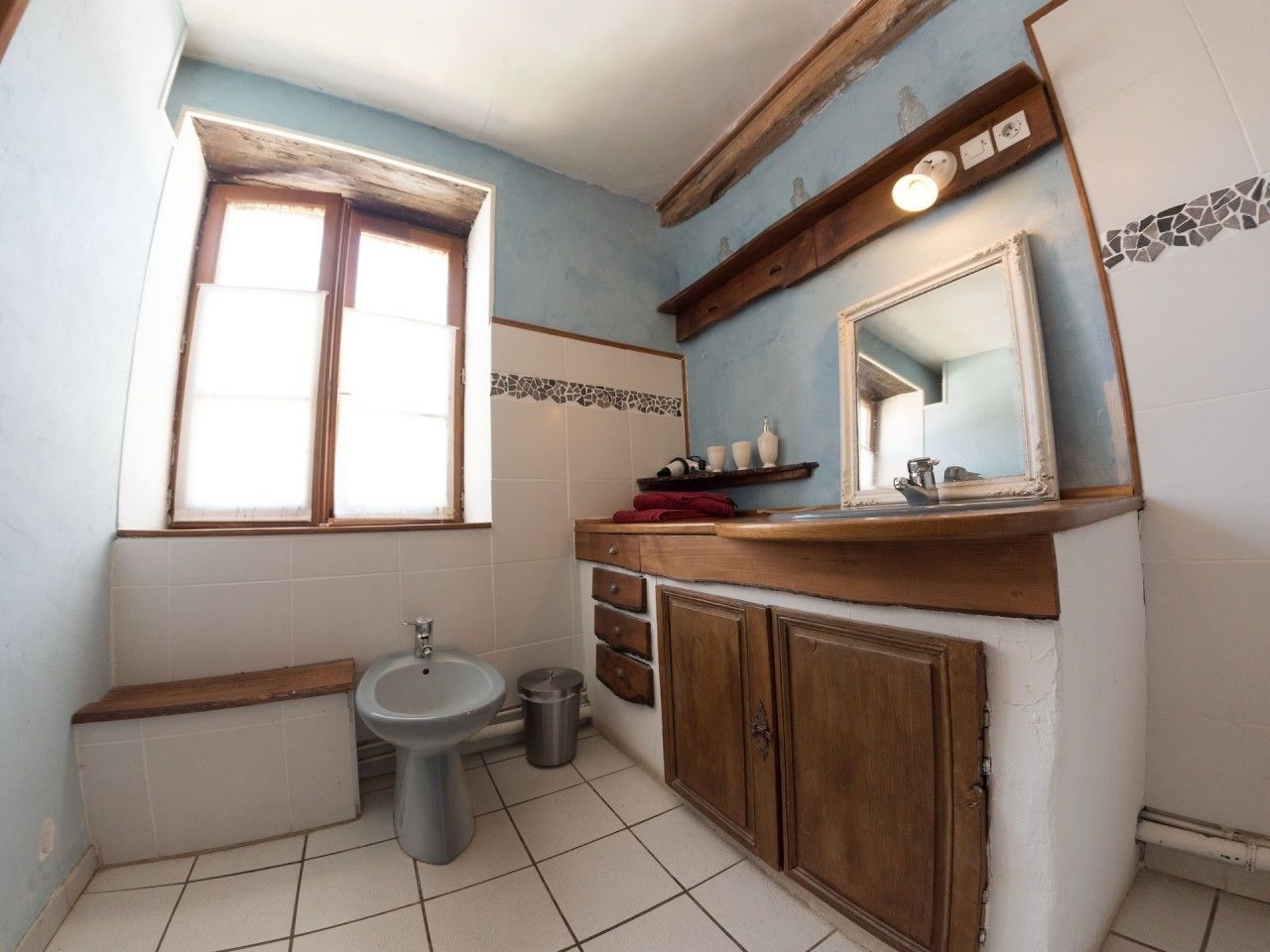 Un bagno piccolo con lavandino, specchio e mobili in legno.
