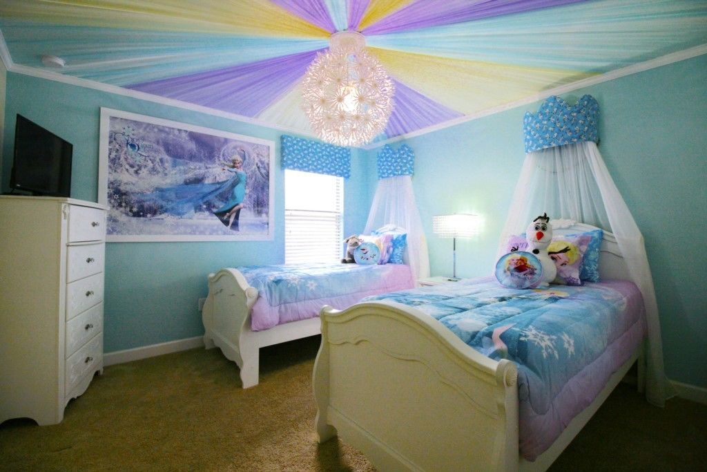 Ein Schlafzimmer mit zwei Betten, einem Schminktisch, einer Chandelüster und einem großen Gemälde an der Wand.
