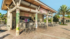 An outdoor tiki bar with wooden pillars, a tiled roof, and outdoor seating. - Je58579 - Champions Gate Resort - 8 Bed 5 Baths Villa (Davenport)