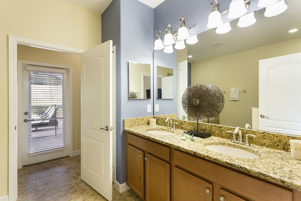 A bathroom with a double sink, a large mirror, and a ceiling light fixture.