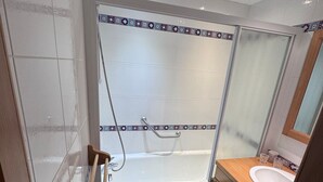 A bathroom with a shower, a bathtub, and a sink.
