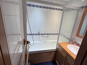 A bathroom with a shower, a bathtub, and a sink.