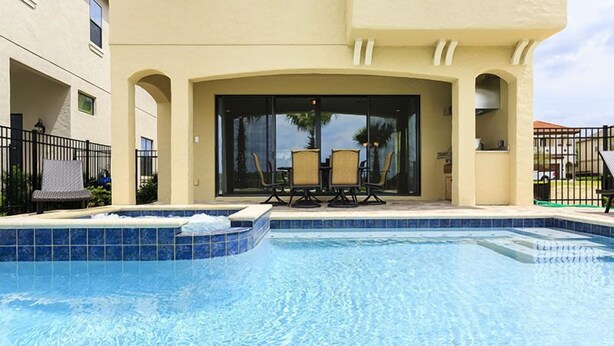 A swimming pool with a patio area, including two chairs and a table. - Je52915 - Reunion Resort - 5 Bed 5 Baths Villa (Kissimmee)