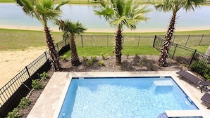A swimming pool with a view of a lake and palm trees. - Je52915 - Reunion Resort - 5 Bed 5 Baths Villa (Kissimmee)