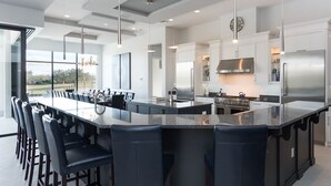 A modern kitchen with a large island, stainless steel appliances, and a view of the outdoors. - Je52232 - Reunion Resort - 11 Bed 10 Baths Villa (Kissimmee)