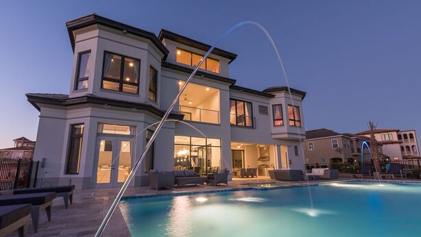 A modern two-story house with a swimming pool, outdoor seating, and a well-lit interior. - Je52232 - Reunion Resort - 11 Bed 10 Baths Villa (Kissimmee)
