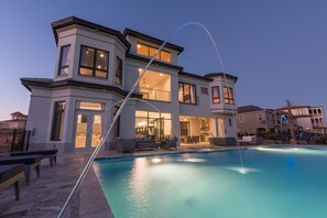 A modern two-story house with a swimming pool, outdoor seating, and a well-lit interior. - Je52232 - Reunion Resort - 11 Bed 10 Baths Villa (Kissimmee)