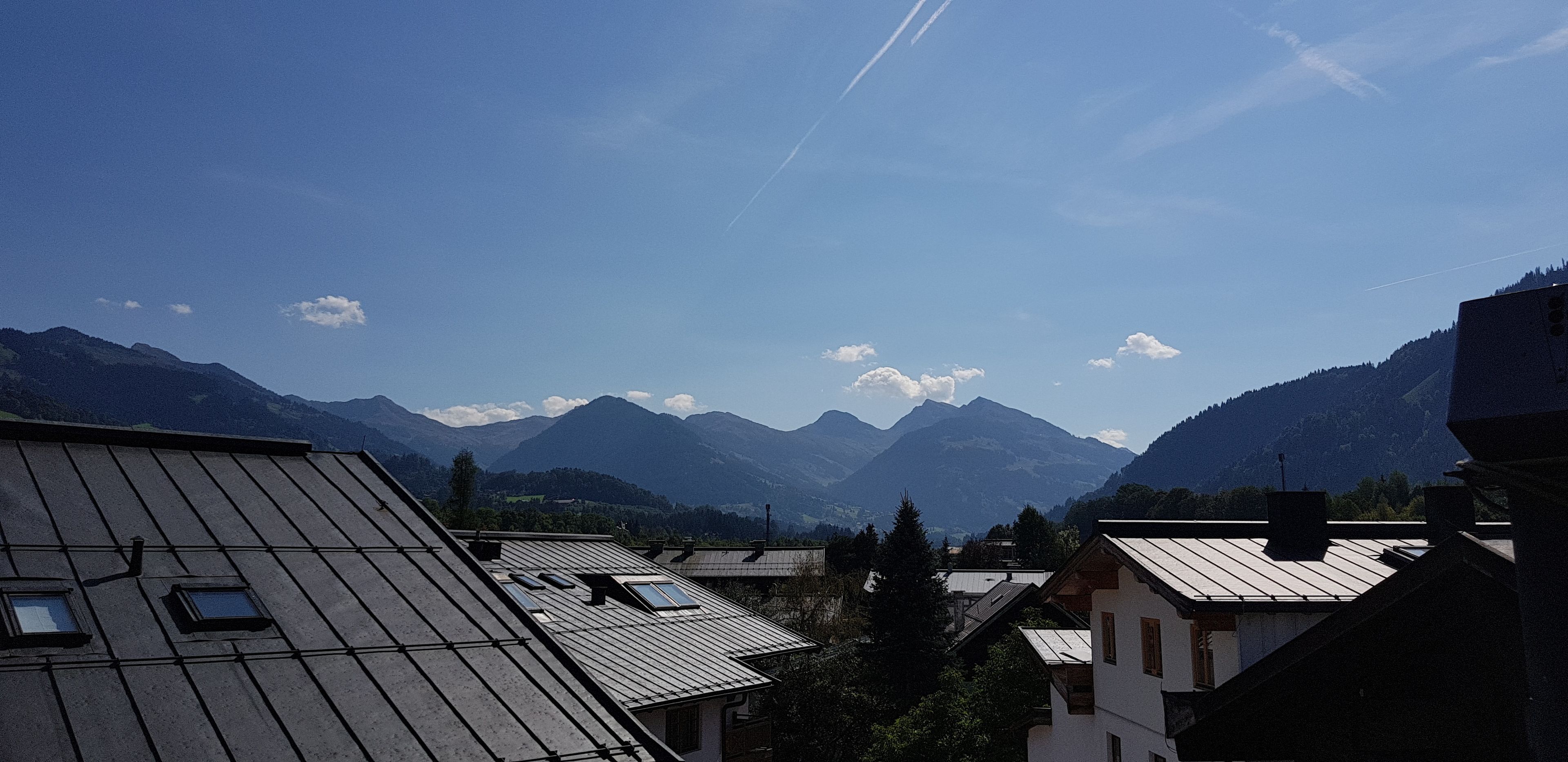 A mountain village with traditional buildings and a clear view of the surrounding mountains.