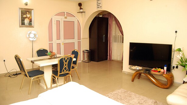 A living room with a dining table, chairs, a TV, and a sofa. - mmmHouse Abuja (Abuja)