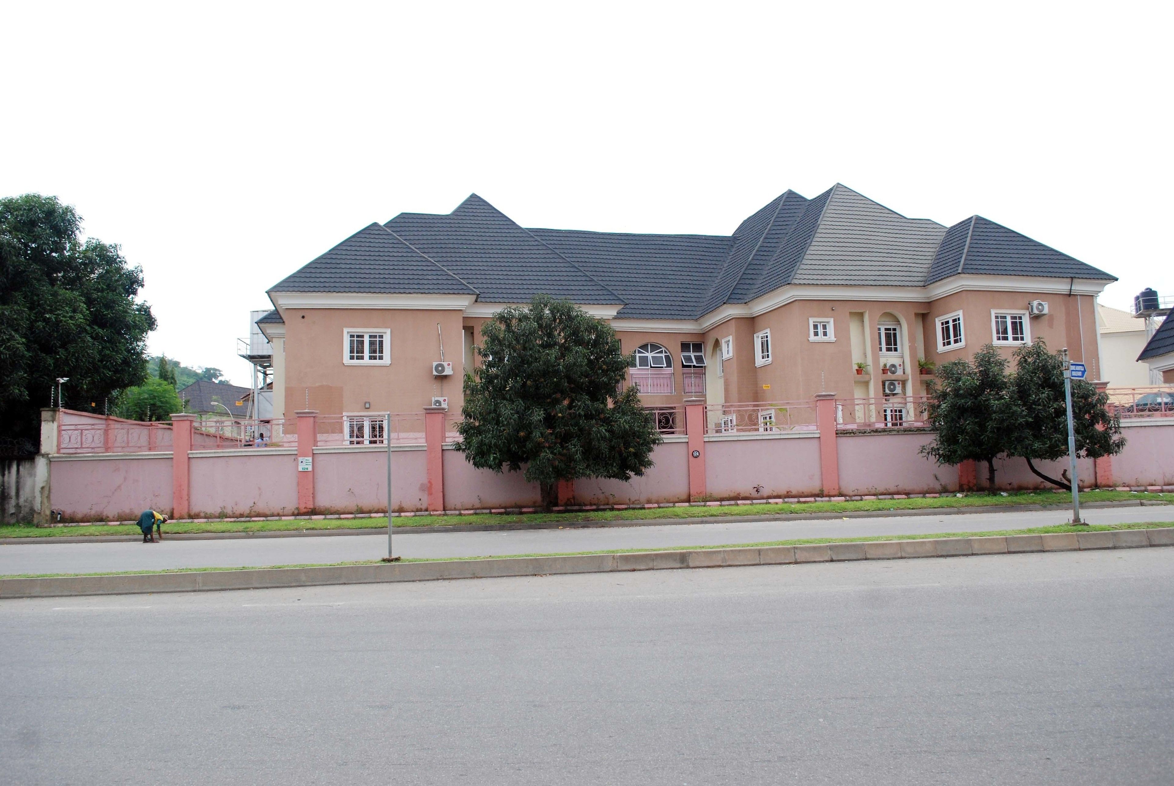 A large, multi-story building with a flat roof and a pink facade.
