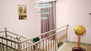 A staircase with a metal railing, a globe on a stand, and a hanging light fixture. - mmmHouse Abuja (Abuja)