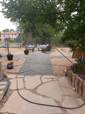 Relax in a serene outdoor space with a hammock, seating area, and play area nearby.