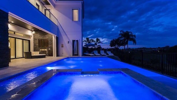 A modern house with a swimming pool at dusk.
