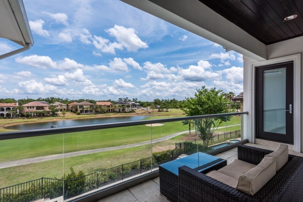 Un balcon avec vue sur un terrain de golf et un lac.