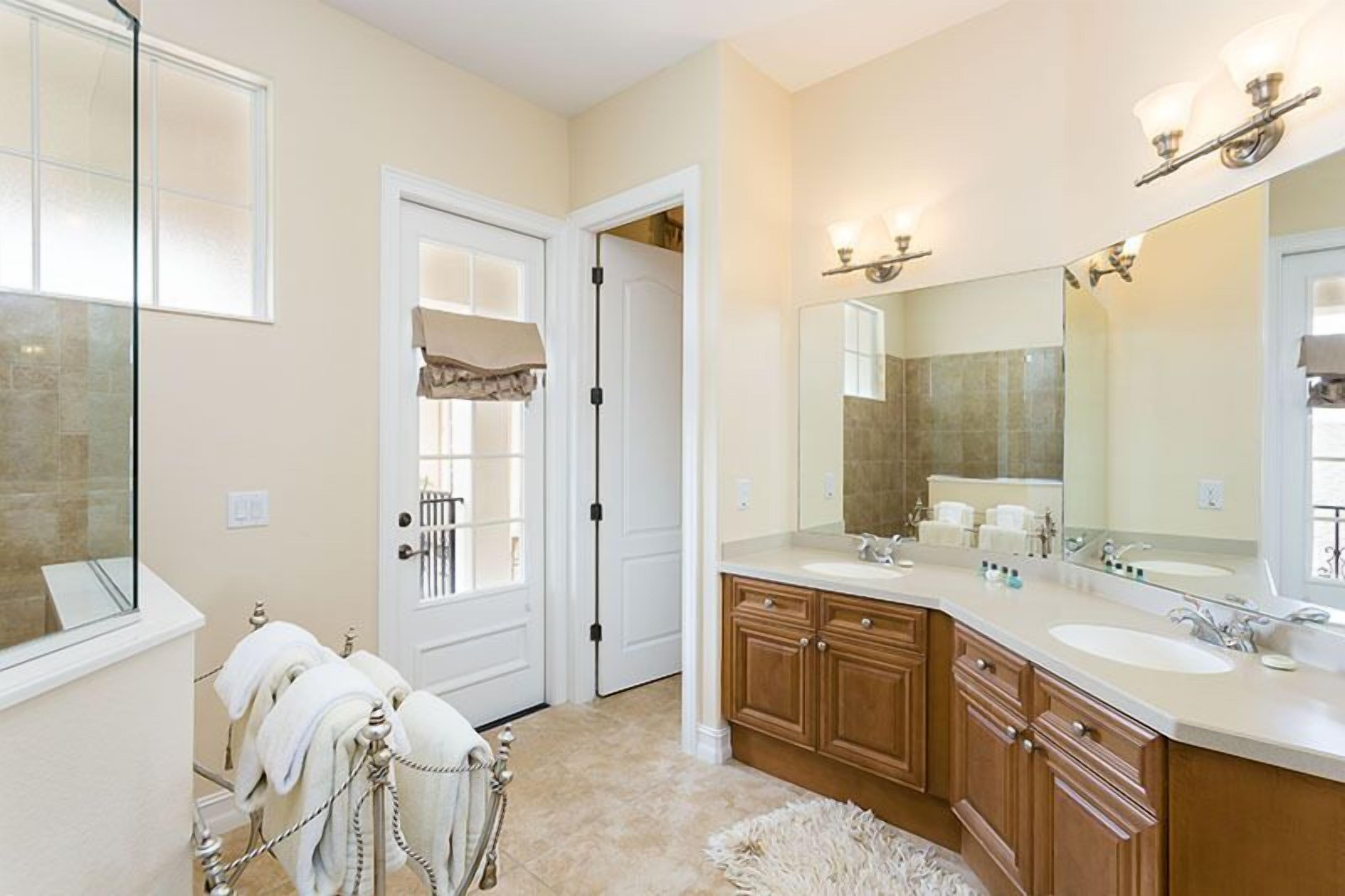 A bathroom with two sinks, a large mirror, and a towel rack.