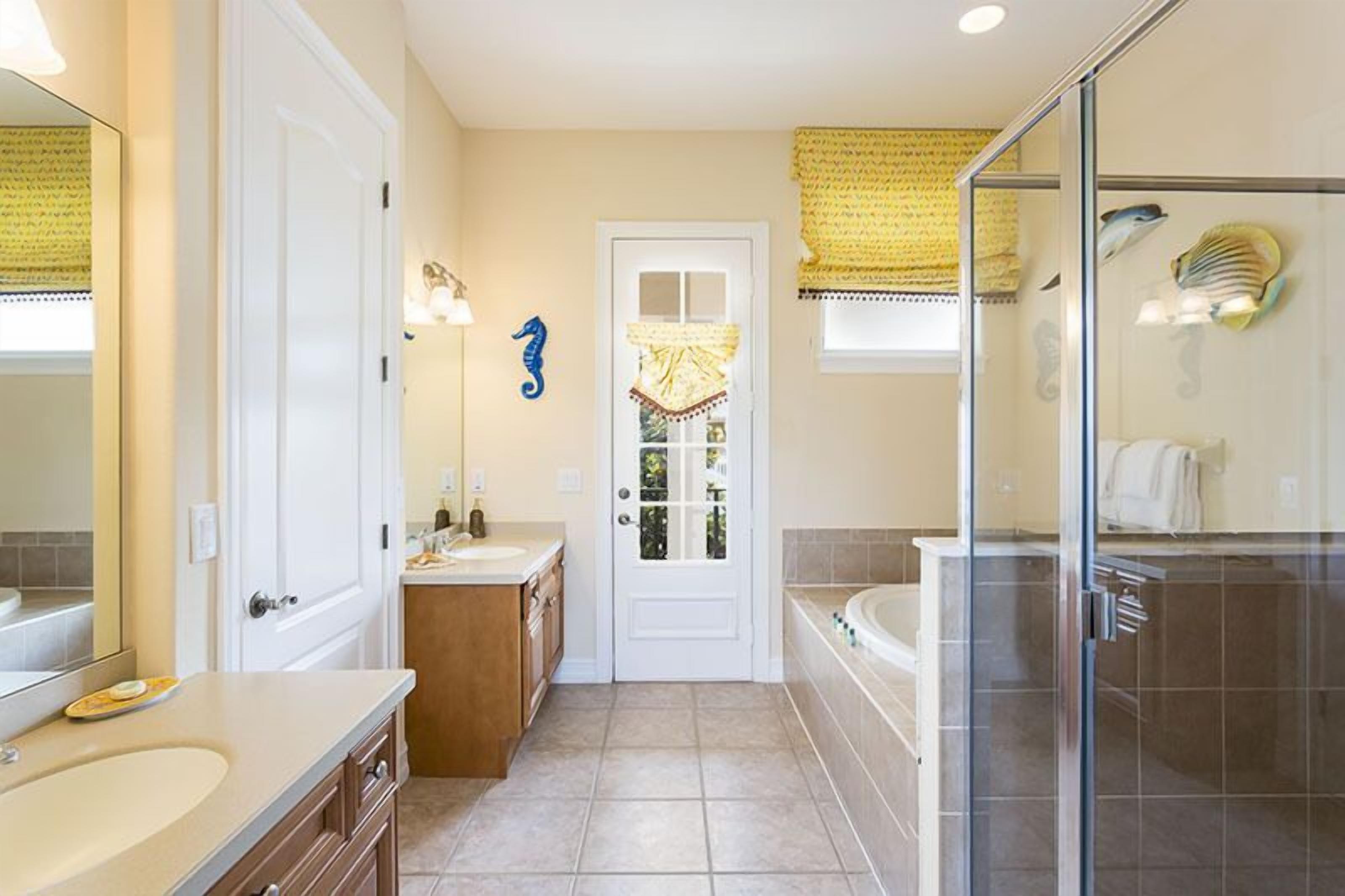 Une salle de bain avec une baignoire, une douche à parois de verre, un lavabo et un meuble-lavabo.