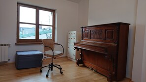Enjoy the city view from this room, featuring a piano for musical moments and a comfortable office chair for productivity.