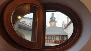 A round window with a view of a building with a clock tower.