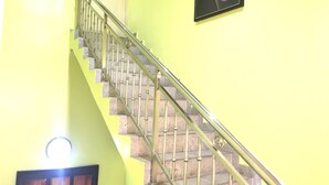 A staircase with a metal railing leading to a landing. - Sun On Hotel (Lagos)
