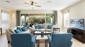 A spacious living room with a large TV, comfortable seating, and a ceiling fan. - Je58253 - Reunion Resort - 6 Bed 5 Baths Villa (Kissimmee)