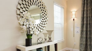 A bathroom vanity with a mirror, a vase of white flowers, and a floor lamp. - Je58253 - Reunion Resort - 6 Bed 5 Baths Villa (Kissimmee)