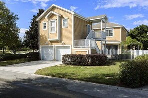 A two-story house with a front garage, a small porch, and a staircase leading to the second floor. - Je58869 - Reunion Resort - 5 Bed 4 Baths Villa (Kissimmee)
