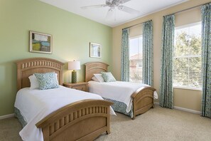 A bedroom with two wooden beds, a ceiling fan, and a window with curtains. - Je58869 - Reunion Resort - 5 Bed 4 Baths Villa (Kissimmee)
