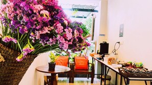Ein Essbereich mit Tisch, Stühlen, einem Blumenkorb und einem kleinen Hocker.