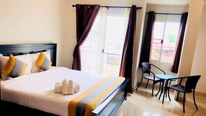 Ein Hotelzimmer mit einem Bett, einem Schreibtisch und zwei Sesseln.