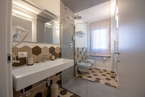 A modern bathroom with a shower, toilet, and sink. - Casa Ercoli (Vinci)