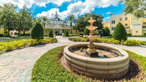 A courtyard with a central fountain, surrounded by well-manicured hedges and a paved walkway. - Je61079 - Reunion Resort - 5 Bed 4 Baths Villa (Kissimmee)