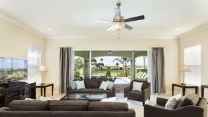 A spacious living room with a large flat-screen TV, comfortable seating, and a ceiling fan. - Je61079 - Reunion Resort - 5 Bed 4 Baths Villa (Kissimmee)