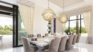 A dining area with a marble table, clear chairs, and two hanging chandeliers. - Je61091 - Reunion Resort - 7 Bed 7 Baths Villa (Kissimmee)