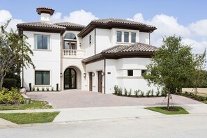 Une maison à deux étages avec une entrée à l’avant, un balcon et une allée.