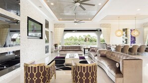 A spacious living area with a large sofa, two armchairs, a coffee table, and a ceiling fan. - Je61091 - Reunion Resort - 7 Bed 7 Baths Villa (Kissimmee)