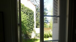 A room with a window overlooking a garden. - La Petite Vigne (Amboise)
