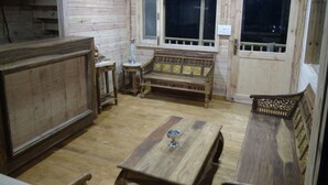 A wooden interior with a wooden bench, a table, and a window. - Rio Resort (Lansdowne)