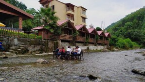 A riverside dining area with a group of people seated at tables. - Rio Resort (Lansdowne)