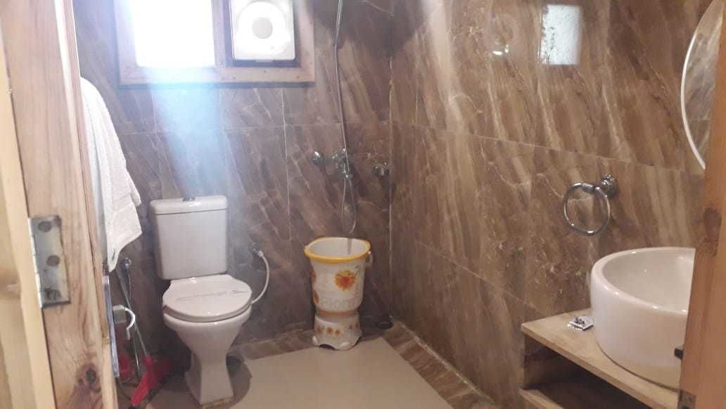 A bathroom with a toilet, a shower, and a sink.