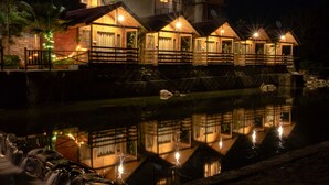 A waterfront hotel with multiple wooden structures, each with a balcony and a reflective pool in front. - Rio Resort (Lansdowne)