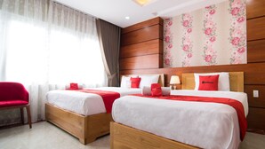 A hotel room with two beds, a red chair, and floral wallpaper. - RedDoorz Plus near Tan Son Nhat Airport 2 (Ho Chi Minh City)