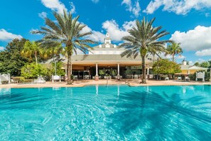 A hotel with a swimming pool, palm trees, and a covered outdoor area. - Je61750 - Reunion Resort - 3 Bed 3 Baths Condo (Kissimmee)