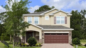 A two-story house with a garage, stone facade, and a well-maintained lawn. - Je62429 - Reunion Resort - 8 Bed 8 Baths Villa (Kissimmee)