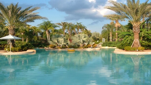 A clear pool surrounded by palm trees and tropical plants. - Je47048 - Reunion Resort - 4 Bed 4 Baths Villa (Kissimmee)