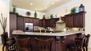 A kitchen with dark wood cabinets, a granite countertop, and a built-in stove.