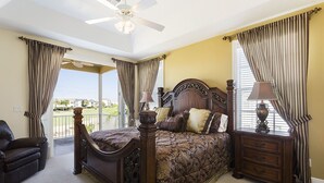 A bedroom with a large bed, a nightstand, a chair, and a ceiling fan. - Je47858 - Reunion Resort - 6 Bed 4 Baths Villa (Kissimmee)
