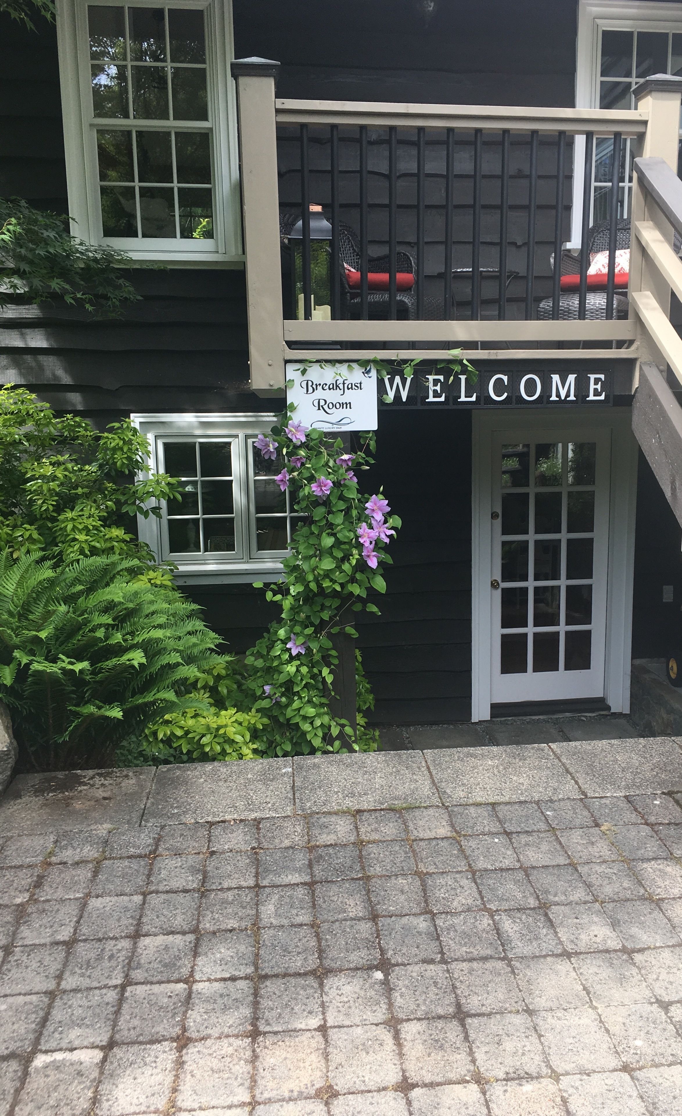 A building with a 'Breakfast Room' sign and a 'Welcome' sign above the door.