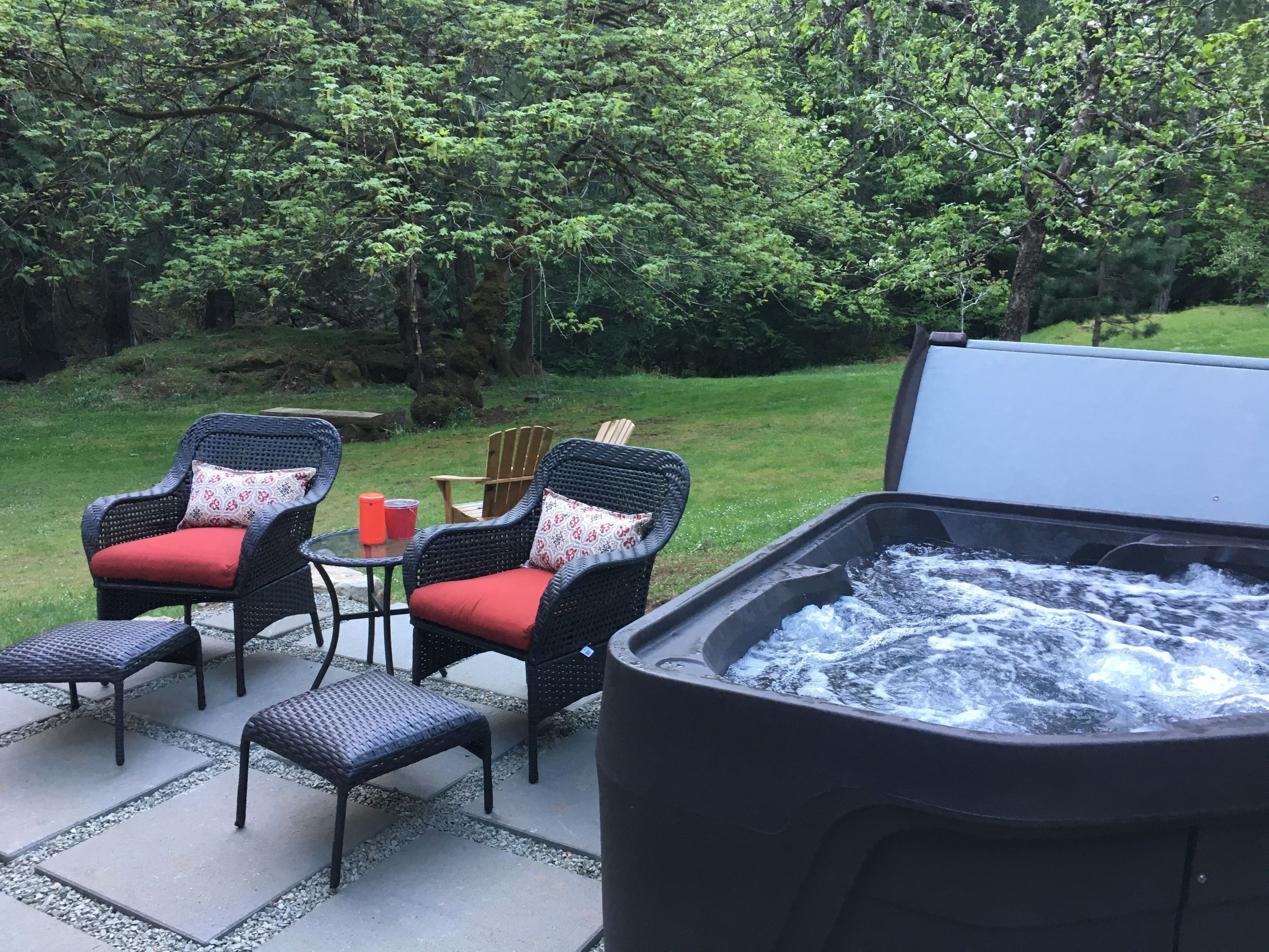 An outdoor seating area with wicker chairs and a hot tub.