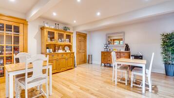 A spacious kitchen with wooden cabinets, a dining table, and chairs.